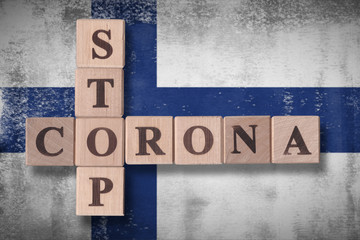 Flag of Finland with wooden cubes spelling STOP CORONA on it. 2019 - 2020 Novel Coronavirus (2019-nCoV) concept art, for an outbreak occurs in Finland.