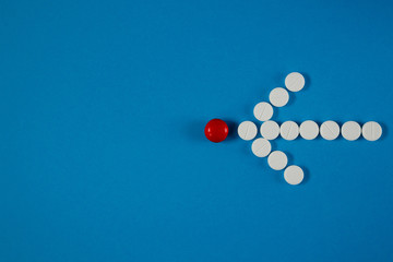 arrow of white pills on a blue background