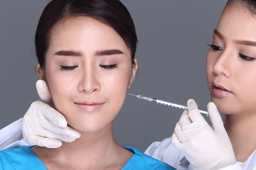 Beautician Doctor put syringe over Face structure patient before plastic surgery
