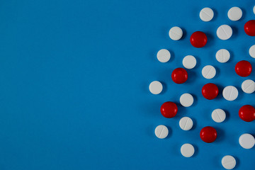 many white and red pills on a blue background