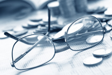 euro coins and glasses on the documents