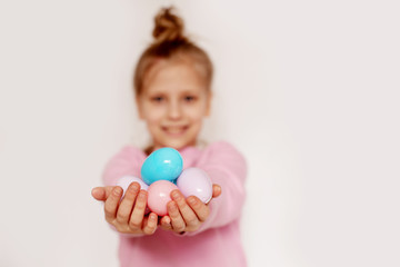 Fototapeta na wymiar A girl holds colorful Easter eggs in her hands. Happy Easter, the concept of the Easter holiday