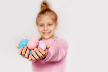 Fototapeta na wymiar A girl holds colorful Easter eggs in her hands. Happy Easter, the concept of the Easter holiday