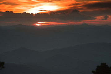 Sun over mountain range in twilight time