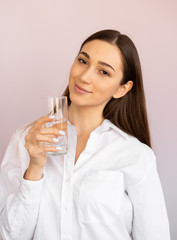  girl drinks water from a glass. body water balance, proper healthy nutrition