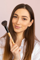 Girl makeup artist with a brush. makeup training for yourself