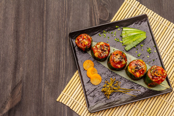 Korean style stuffed cucumbers. Kojori kimchi spicy snack. Fermented and marinated vegetables. Wooden background