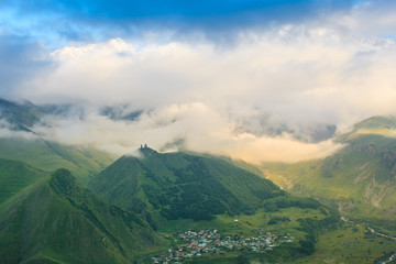 Obraz premium beautiful mountain landscape with fog in Georgia in summer sunny day. wide nature and locality in Georgia. clouds on blue sky background in mountain 