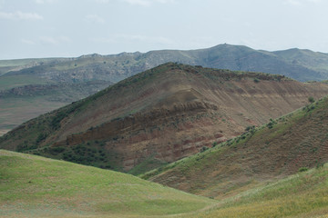 
low mountainous terrain in georgia. rocky and stony hills and slopes covered with grass in spring