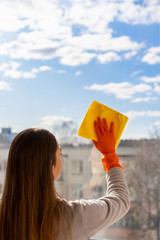  washing windows with gloves. girl cleaning the apartment