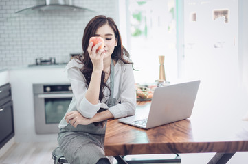 Portrait of beautiful young latin woman talking over the phone while cooking in kitchen