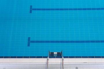 Swimming pool edge with a steel ladder Top view Empty sports swimming pool Horizontal orientation....