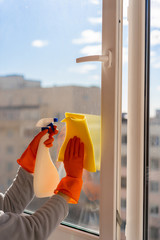  washing windows with gloves. girl cleaning the apartment