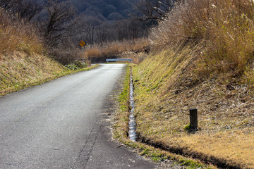 春先の田舎道の排水溝 a gutter 