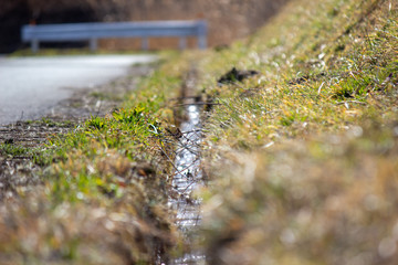 春先の田舎道の排水溝 a gutter 