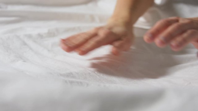household, housework and cleaning concept - hands of woman making bed linen