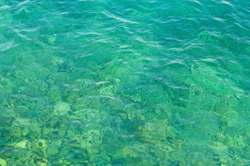Fototapeta na wymiar Blue green transparent lake water texture. Background of tranquil water. Summer vacation concept.