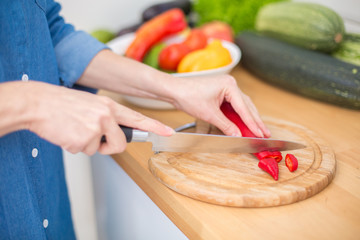 Woman slicing paprika at a kitchen 