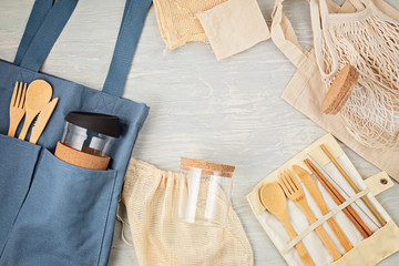 Fototapeta na wymiar Flat lay of Zero waste kit. Set of eco friendly bamboo cutlery, mesh cotton bag, reusable coffee tumbler, brushes and water bottle. Sustainable, ethical, plastic free lifestyle