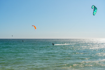 The athlete practices kate board surfing the sea on the waves. Summer in Portugal Algarve.