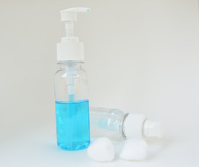 Alcohol bottle, press type, cotton ball, gel bottle to wash hands falling on a white background