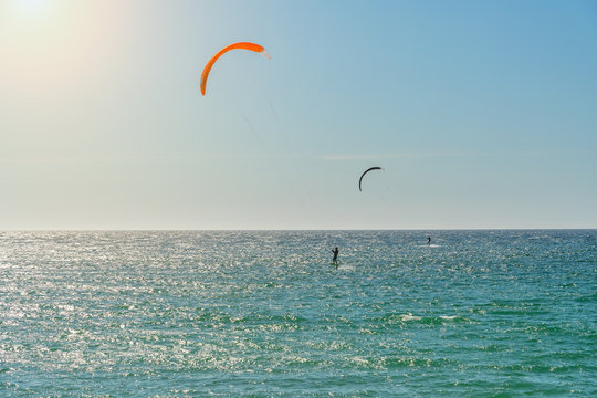 The athlete practices kate board surfing the sea on the waves. Summer in Portugal Algarve.
