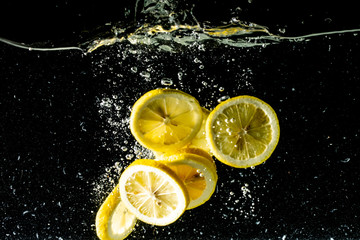 lemon slices in water splashes  isolated on black background