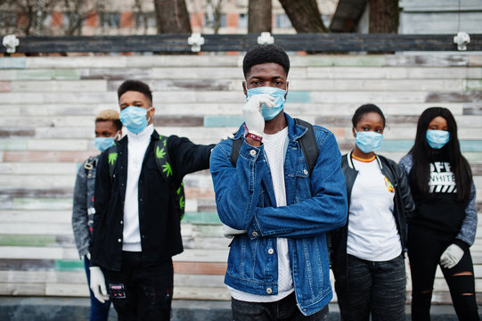 Group of african teenagers friends wearing medical masks protect from infections and diseases coronavirus virus quarantine.