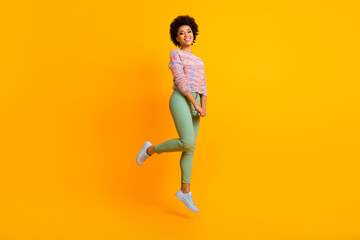 Fototapeta na wymiar Full body photo of cute sweet afro american girl jump enjoy autumn spring free time feel carefree emotions wear good look outfit isolated over yellow color background