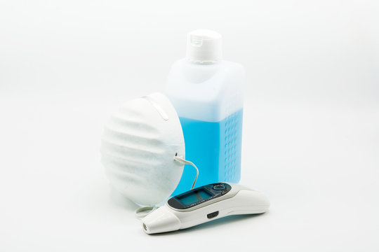Disinfectant, thermometer and  face mask on white background