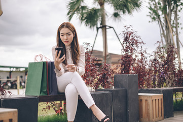 Young woman with shopping bags walking out from shop