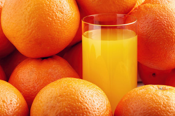 Glass of orange juice surruonded by oranges. Healthy vitamin c beverage