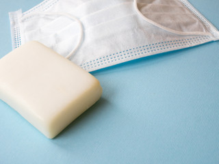 Close up image of medical mask with soap on the blue background. Medicine concept