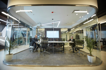 Wide angle view at futuristic office interior with glass conference room in center, copy space