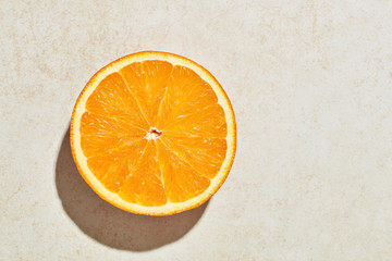 One slice of orange under harsh sunlight with copy space
