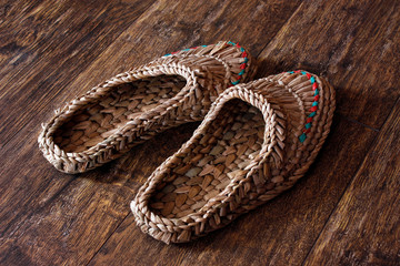 Fototapeta na wymiar Wicker home low slippers, bast shoes or Lapti woven from wood bast. A modern version of old traditions.