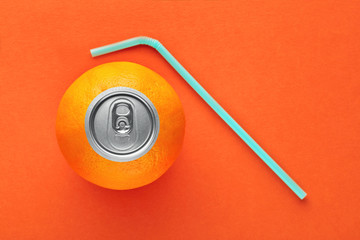 Orange fruit with pop up silver top of a can and a straw on orange background