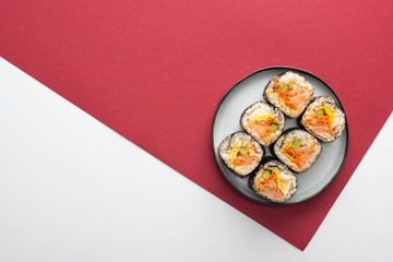 top view of plate with gimbap on white and crimson