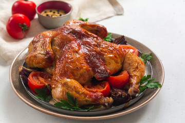 Roasted  chicken with garlic, spices and vegetables: tomatoes, red onions.