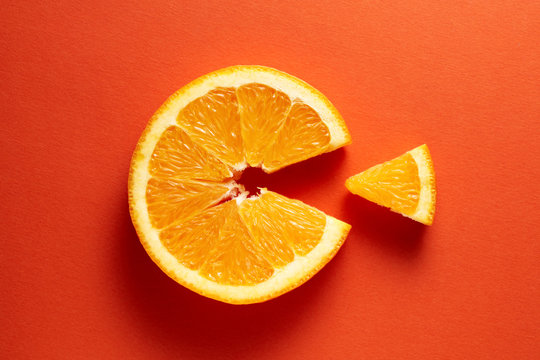Orange slice symbolizing vitamin c is eating the cut out piece on orange background