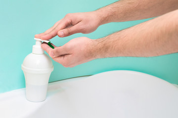 washing and disinfecting hands from germs and viruses using soap foam and water jet on a blue background. coronavirus pandemic, personal health protection.
