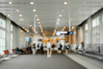 Blur background of traveler at airport terminal with bokeh light.