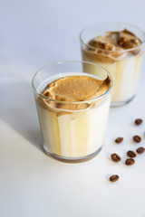 South Korean coffee dalgona – trendy cold latte or cappuccino with milk and cane sugar. Summer drink for breakfast