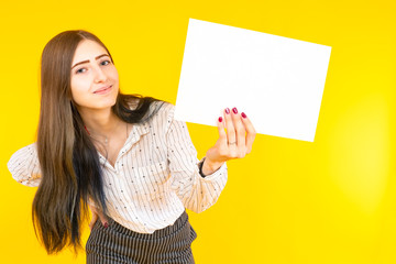 Woman with white paper in her hands. Girl shows a white sheet. Young woman shows a blank sheet....