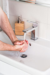 Hand washing with soap in bathroom to prevent contamination, close up