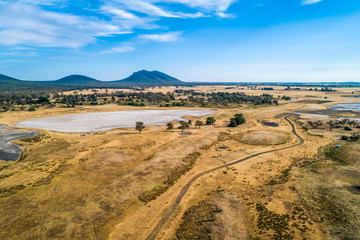 Fototapeta na wymiar Australian pastures in the outback in bright daylight - aerial view