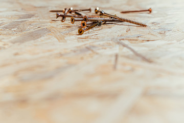 Screws on a wooden table background, screwdriver housework repairmen.