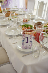 Table setting with wineglasses, plates and cutlery on table, copy space. Place setting at wedding reception. Table served for wedding banquet in restaurant