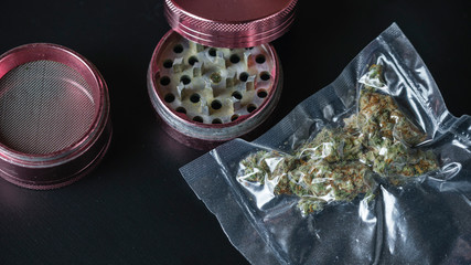 Close-up of medical marijuana buds in vacuum seal bags and grinder.