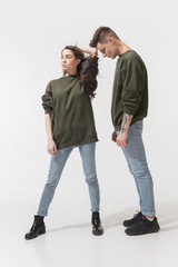Freedom in choice. Trendy fashionable couple isolated on white studio background. Caucasian woman and man posing in basic minimal unisex clothes. Concept of relations, fashion, beauty, love. Inclusive